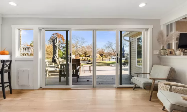 Doorway to outside featuring crown molding and light hardwood / wood-style floors