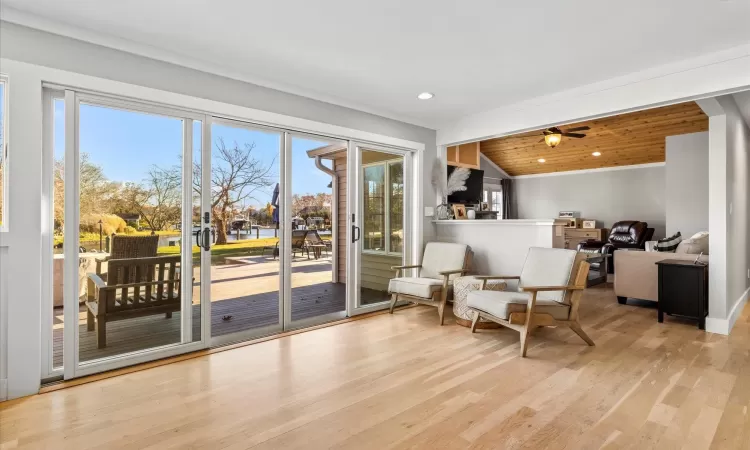 Living area with light hardwood / wood-style floors, vaulted ceiling, ceiling fan, and wood ceiling