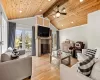 Living room with lofted ceiling with beams, plenty of natural light, light hardwood / wood-style flooring, and wood ceiling