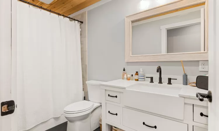 Full bathroom with vanity, toilet, and shower / bath combination with curtain