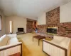 Carpeted living room with vaulted ceiling and a brick fireplace