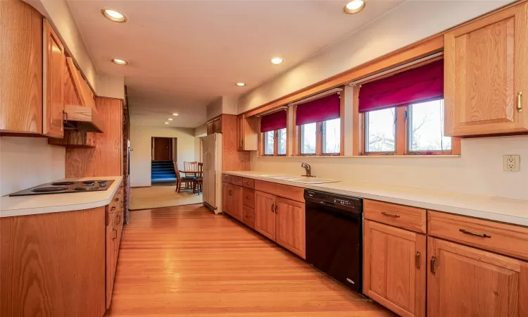 Kitchen with black appliances, sink, and light hardwood / wood-style floors