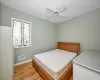 Bedroom with ceiling fan, light hardwood / wood-style flooring, and white fridge