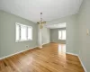 Unfurnished room featuring a notable chandelier and light hardwood / wood-style flooring