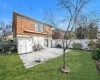 Back of property featuring a storage unit, a patio, and a lawn