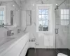 Bathroom featuring a shower with shower door, vanity, and radiator heating unit