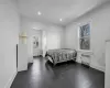 Bedroom with dark wood-type flooring and radiator heating unit