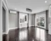 Unfurnished room with a wall unit AC, dark hardwood / wood-style flooring, and ornamental molding