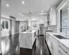 Kitchen with white cabinetry, stainless steel fridge, decorative backsplash, sink, and a center island