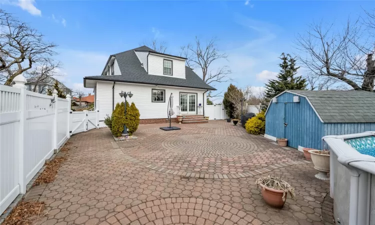 Rear view of property featuring a storage shed and a patio