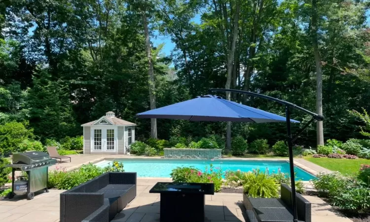 View of swimming pool featuring area for grilling, a patio area, and an outdoor structure