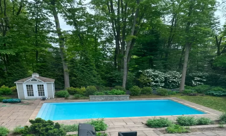 View of pool featuring a patio area and an outbuilding