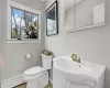 Bathroom with toilet, a baseboard heating unit, and tile patterned flooring