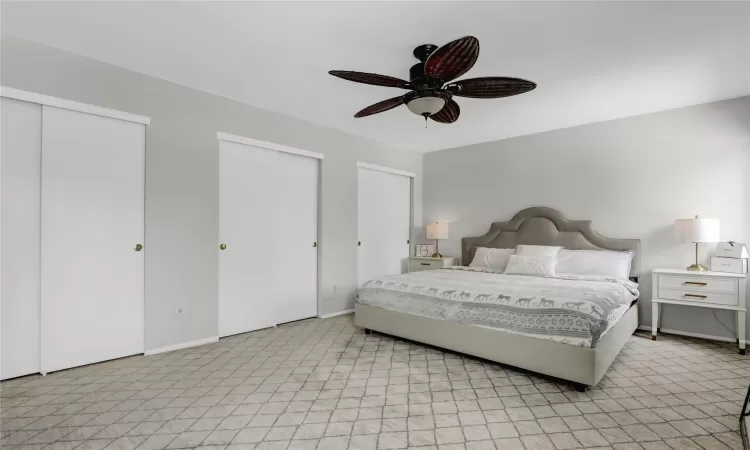 Bedroom featuring ceiling fan and multiple closets