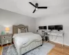 Bedroom with ceiling fan, a baseboard radiator, and light hardwood / wood-style flooring