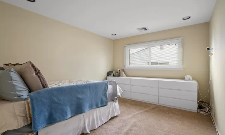 Bedroom featuring light colored carpet