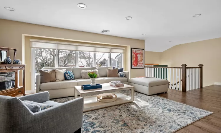 Living room featuring wood-type flooring and lofted ceiling