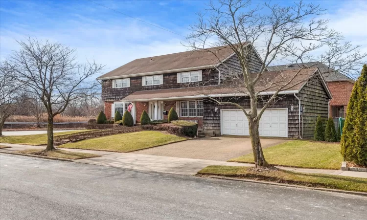 View of front of home with a garage and a front yard