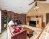 Carpeted living room with a wood stove, high vaulted ceiling, and ceiling fan