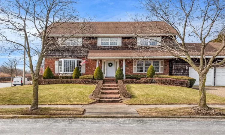 View of front of home with a front yard and a garage