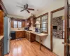 Kitchen featuring ceiling fan, sink, decorative light fixtures, light hardwood / wood-style flooring, and stainless steel appliances