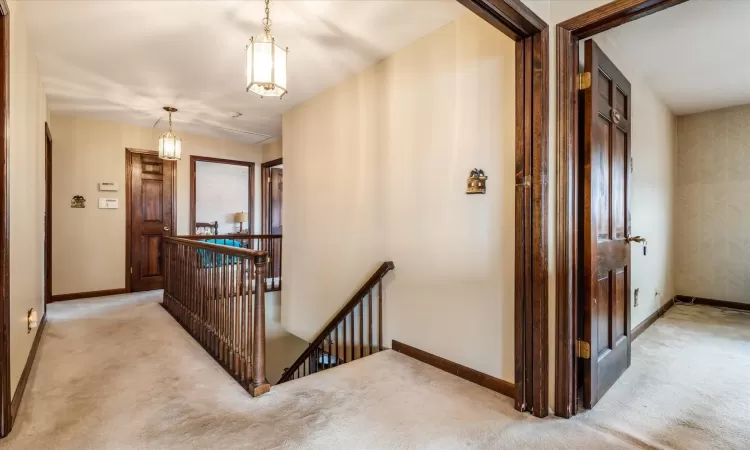 Corridor featuring light colored carpet