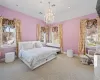 Carpeted bedroom with an inviting chandelier