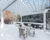 Snow covered patio featuring a pergola