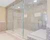 Bathroom featuring tile walls, walk in shower, and tile patterned flooring