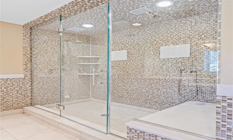 Bathroom featuring tile walls, walk in shower, and tile patterned flooring