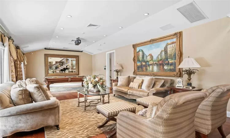 Living room with hardwood / wood-style floors and lofted ceiling