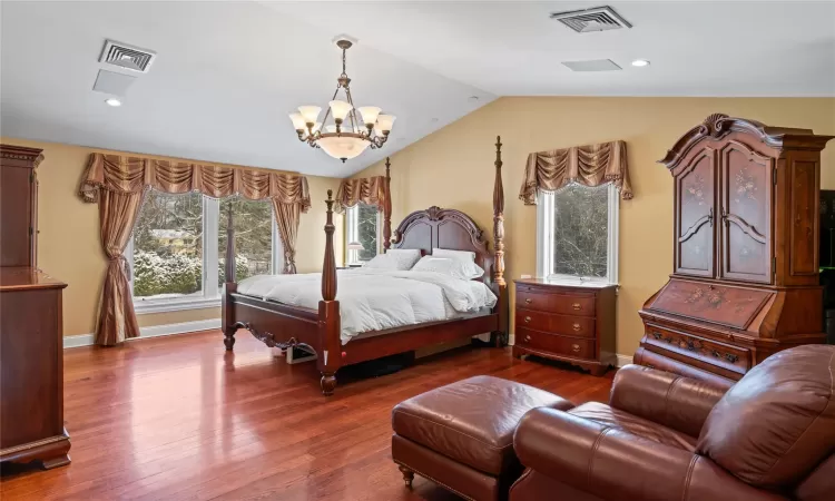 Bedroom with lofted ceiling, a chandelier, and hardwood / wood-style floors