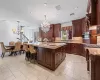 Kitchen featuring a notable chandelier, stainless steel oven, pendant lighting, and an island with sink