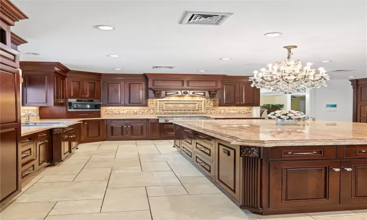 Kitchen with a kitchen island, backsplash, and decorative light fixtures