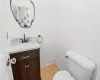 Bathroom featuring toilet, water heater, and vanity