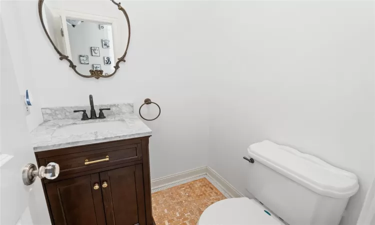 Bathroom featuring toilet, water heater, and vanity