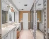 Bathroom featuring vanity, tile patterned flooring, tile walls, and walk in shower