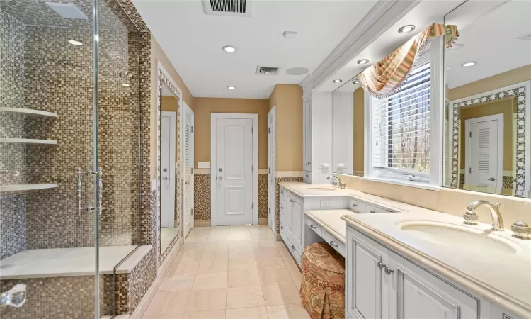 Bathroom featuring a shower with shower door, vanity, and tile patterned flooring