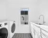 Washroom featuring sink, independent washer and dryer, and cabinets