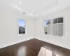 Empty room featuring dark hardwood / wood-style floors and a raised ceiling