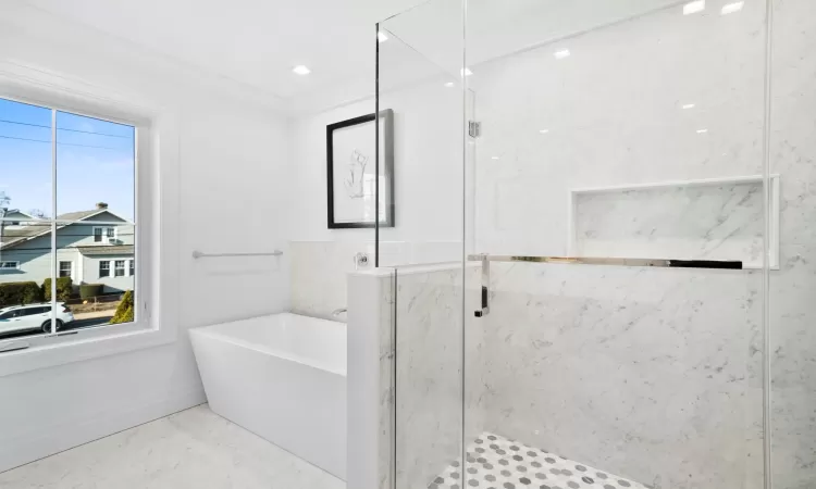 Bathroom featuring ornamental molding and plus walk in shower