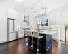 Kitchen featuring wall chimney range hood, white cabinets, and premium appliances