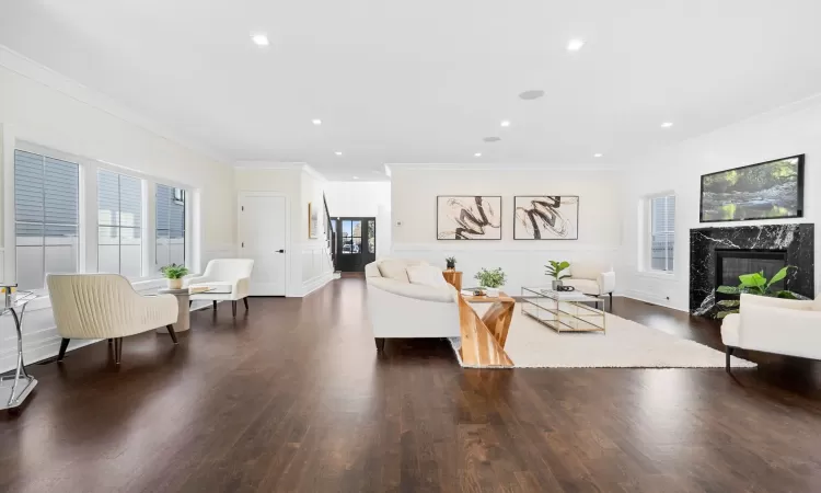 Living room with a high end fireplace, crown molding, and dark hardwood / wood-style floors