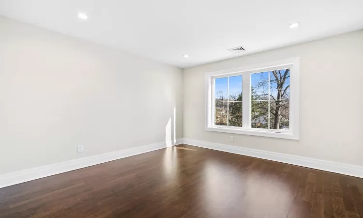 Empty room featuring dark hardwood / wood-style flooring