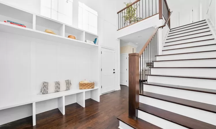 Mudroom featuring dark hardwood / wood-style floors and a high ceiling