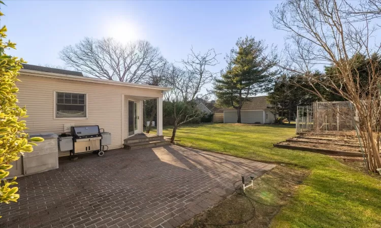 View of patio featuring grilling area, an outbuilding, and a garage