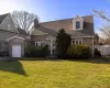 New england style home featuring a front yard