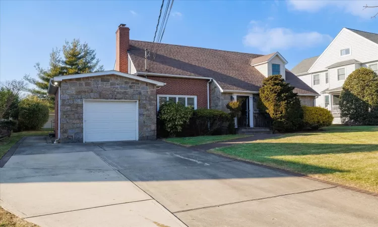 View of front of house featuring a garage and a front yard