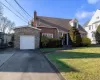 View of front of house with a garage and a front yard