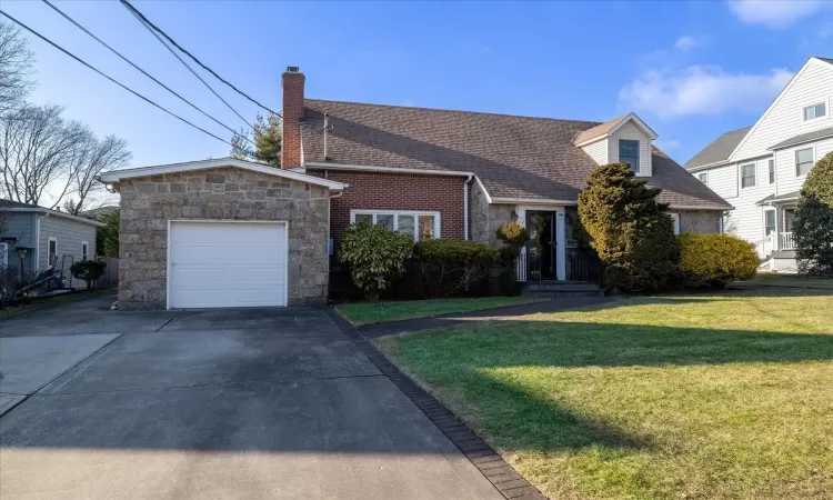 View of front of house with a garage and a front yard